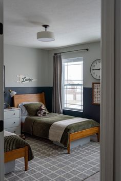 a bedroom with two beds and a clock on the wall