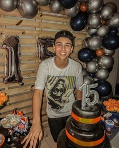 a young man standing in front of a birthday cake