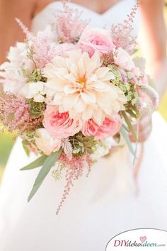 a bridal holding a bouquet of pink and white flowers