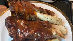 a close up of a plate of food with meat and bread on it, covered in gravy