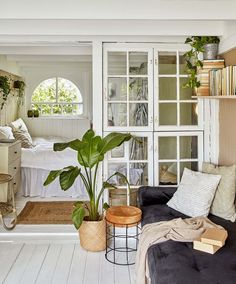 a living room filled with furniture and plants