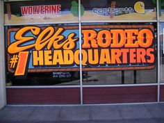 a store front window with an advertisement for the 7 - eleven's rodeo headquarters