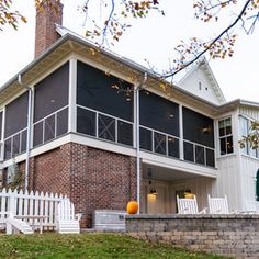 a house with a white picket fence around it and an orange pumpkin on the lawn