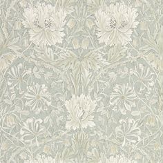 an ornate wallpaper with white flowers and leaves on it's side, in grey tones