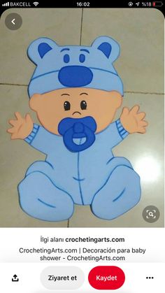 the baby is wearing a blue bear suit and holding his hands up to his mouth