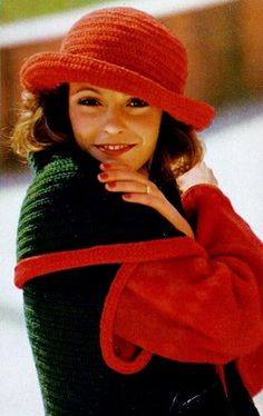 a young woman wearing a red hat and black sweater posing for the camera with her hand on her chin