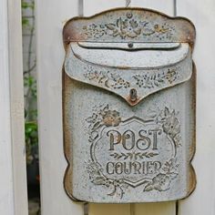 an old fashioned mailbox is attached to a white fence