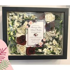 a wedding card and flowers in a shadow box