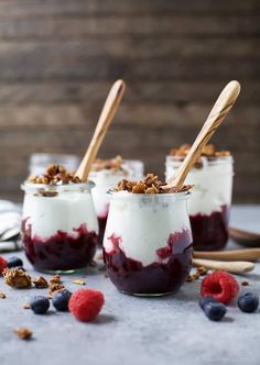 three glasses filled with dessert sitting on top of a table