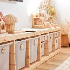 several storage bins are lined up on the floor in front of a white wall