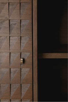 a close up of a wooden cabinet with geometric designs on the doors and shelves behind it