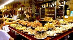 people are sitting at a bar with food on the table and in front of them