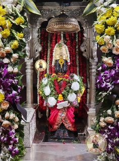 an idol is surrounded by flowers and other decorations