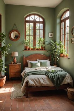 a bedroom with green walls and plants on the windows sill, bed in foreground