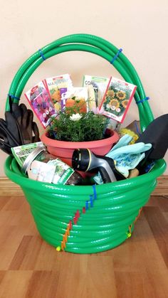 a green basket filled with gardening items on top of a wooden floor