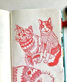 an open book with two cats in sweaters