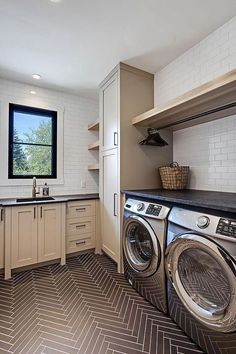 a washer and dryer in a very large room with tile flooring on the walls