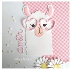 a close up of a card with a sheep on it and flowers in the background