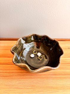 two wedding rings in a bowl on a wooden table