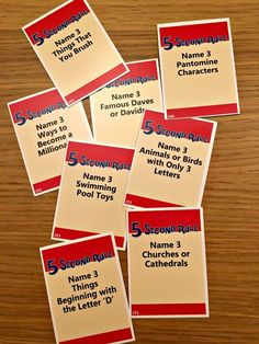 several red and white business cards sitting on top of a wooden table