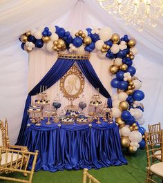 a blue and gold themed party with balloons on the ceiling, table set up for an event