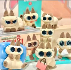 several small stuffed animals sitting next to each other in front of a box with tags on it