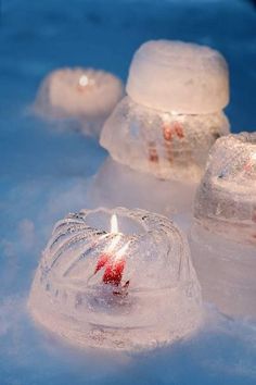 three lit candles sitting on top of ice