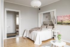 a white bed sitting in a bedroom next to a doorway