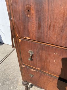 an old wooden filing cabinet sitting on the sidewalk