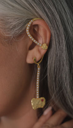 a close up of a person wearing some kind of earring with pearls on it