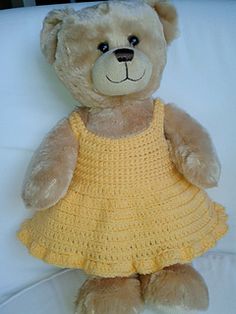 a brown teddy bear wearing a yellow dress