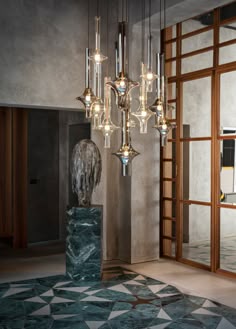 an elegant chandelier hangs from the ceiling in a room with marble floors and walls