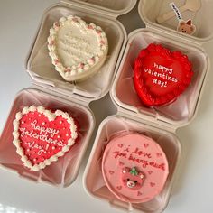 four valentine's day cookies in plastic containers with writing on them