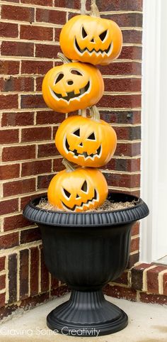 pumpkins stacked on top of each other in a planter