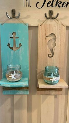 two mason jars with seahorses on them are hanging from the wall