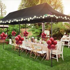 an outdoor dining area set up for a party with balloons and string lights on the tables