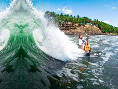 a man riding a wave on top of a surfboard in the ocean next to an island