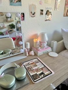 there is a table with some pictures on the wall and candles in front of it