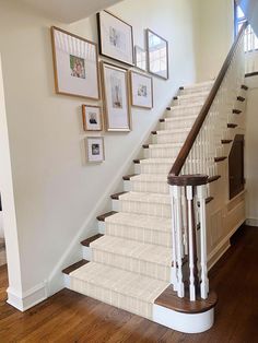 a staircase with pictures on the wall above it