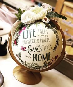 a globe with flowers on it sitting on top of a table