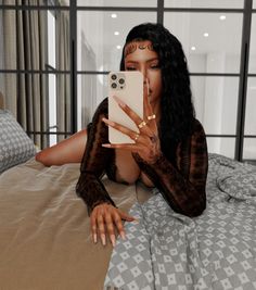 a woman laying on top of a bed holding a cell phone