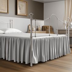 a white bed sitting on top of a wooden floor