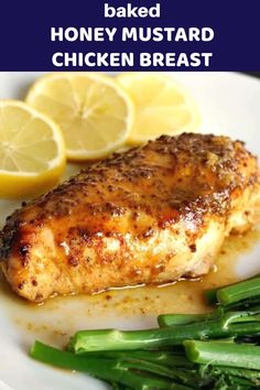 baked honey mustard chicken with asparagus and lemon wedges on a white plate