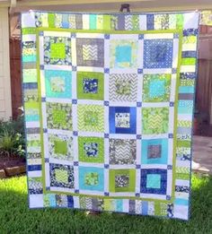 a green and blue quilt on the grass