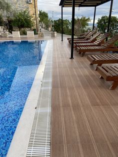 an empty swimming pool with lounge chairs next to it