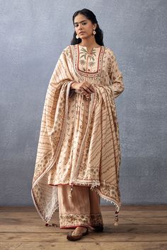 Beige front gathered kurta with botanic digital and hand block print. Paired with printed pant and printed tassel dupatta.
Components: 3
Pattern: Printed
Type Of Work: Digital Print, Hand Block Print
Neckline: Notched
Sleeve Type: Long
Fabric: Slub Silk, Cotton Silk
Color: Beige
Other Details: 
Printed pant
Tassel dupatta
Occasion: Mehendi and Haldi - Aza Fashions Tassel Dupatta, Beige Color Scheme, Eastern Wear, Cotton Silk Fabric, Kurta Pant Set, Elegant Sets, Hand Block Print, Kurta With Pants, Fashion App