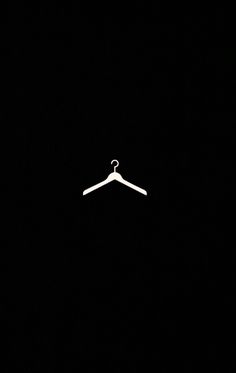 a white hanger on a black background in the dark