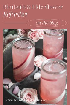 three jars filled with pink liquid next to flowers