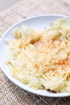 mashed potatoes in a white bowl with seasoning on top