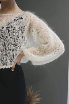 a close up of a woman wearing a sweater with lace on the shoulders and sleeves